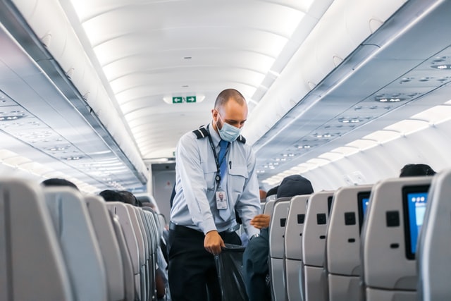 airatendant with mask inside an airplane